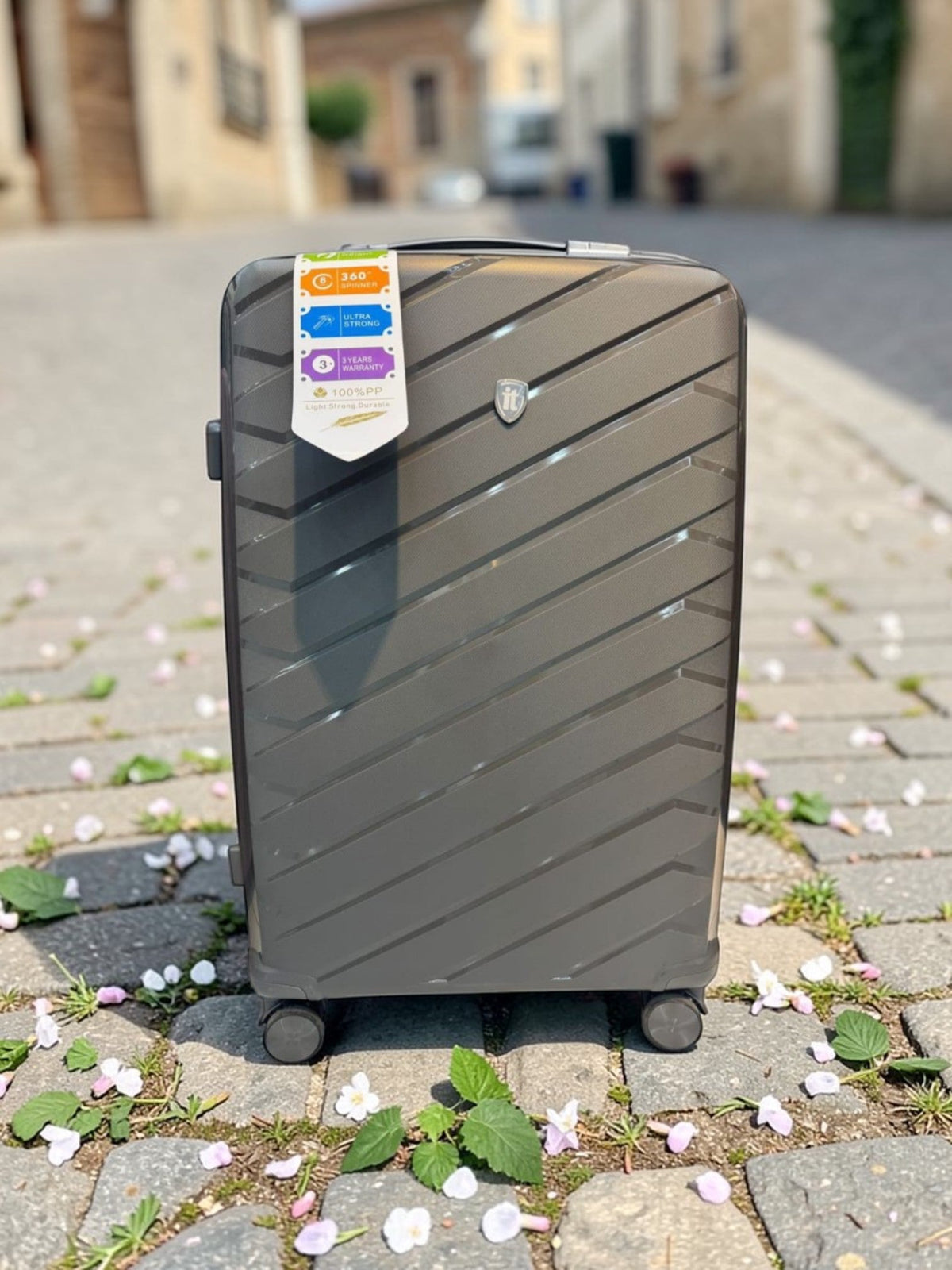 Fixed Price Shop IT Luggage PP trolley in dark grey with a diagonal textured finish and 360-degree spinner wheels.