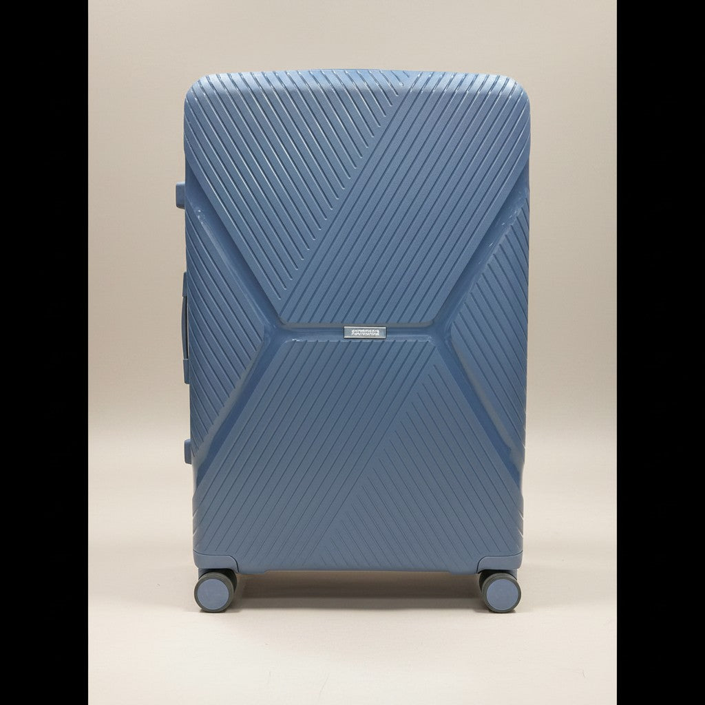 American Tourister blue hardshell luggage with textured geometric pattern and TSA-approved lock. Features 360-degree wheels.
