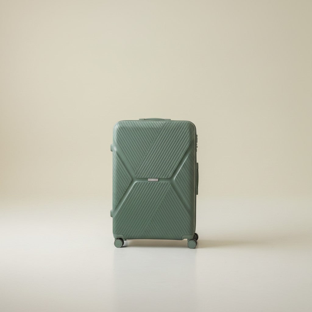 American Tourister sage green hardshell luggage with textured geometric pattern, 360 wheels, and TSA lock. Model sits beside it.